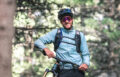 Oli Dorn in voller MTB Montur und mit Sonnenbrille mit seinem Bike